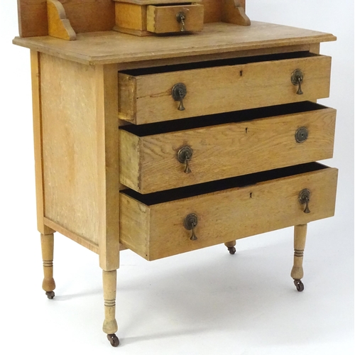 41 - An early 20thC oak dressing table with an oval mirror above three long drawers. 33