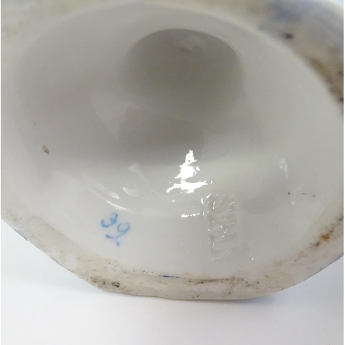 410 - A pair of German posy holders / bud vases of flower form with cherub detail. Impressed mark under SP... 