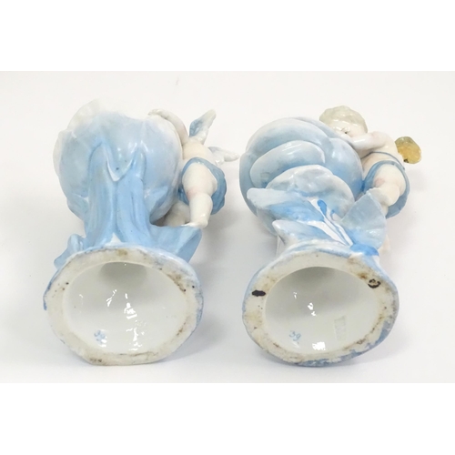 410 - A pair of German posy holders / bud vases of flower form with cherub detail. Impressed mark under SP... 