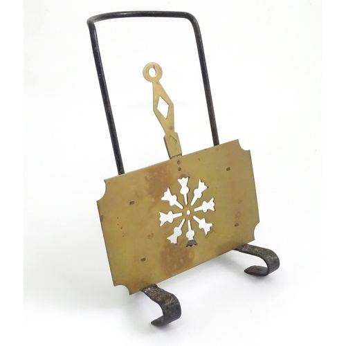 419 - A Victorian brass and cast iron sliding fireside trivet with hanging hooks and pierced detail. Appro... 
