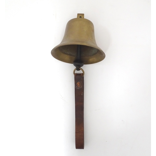 49 - A late 19thC brass hanging bell with leather strap, approx 5 1/2