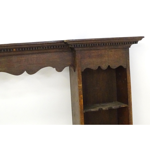 683 - An 18thC oak plate rack with a moulded cornice above a shaped frieze and two cupboards. 74