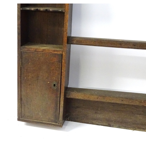 683 - An 18thC oak plate rack with a moulded cornice above a shaped frieze and two cupboards. 74