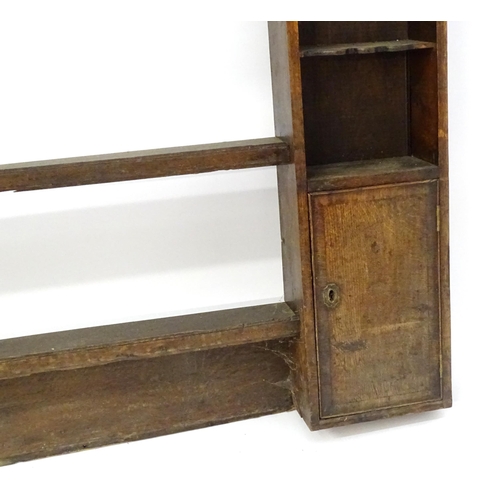 683 - An 18thC oak plate rack with a moulded cornice above a shaped frieze and two cupboards. 74