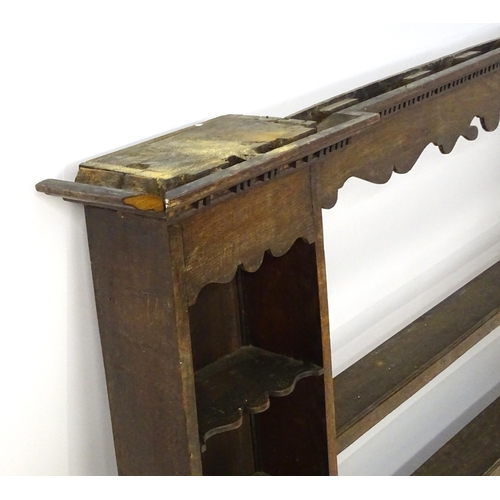 683 - An 18thC oak plate rack with a moulded cornice above a shaped frieze and two cupboards. 74