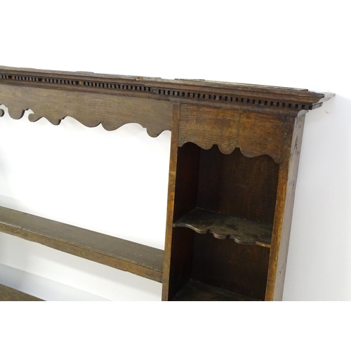 683 - An 18thC oak plate rack with a moulded cornice above a shaped frieze and two cupboards. 74