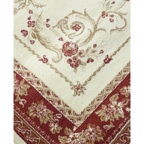 700 - Carpet / Rug : A cream ground rug with floral and acanthus detail within red ground borders. Approx ... 