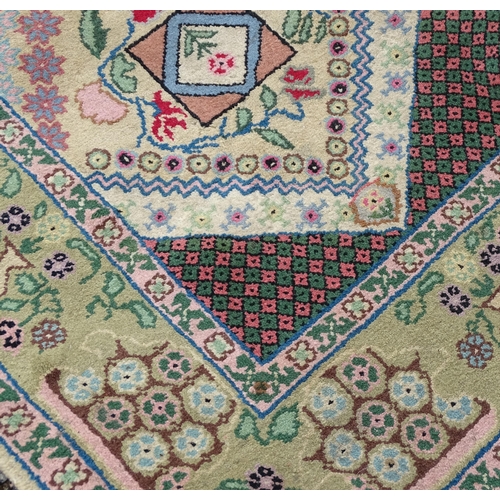 701 - Carpet / Rug : A cream and green ground rug profusely decorated with floral detail with vases, trees... 