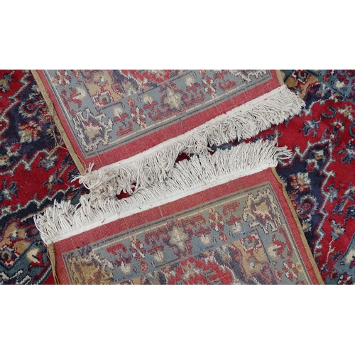 702 - Carpet / Rug : A pair of red and blue ground rugs with floral and folate detail.  Each approx 53
