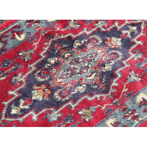 702 - Carpet / Rug : A pair of red and blue ground rugs with floral and folate detail.  Each approx 53