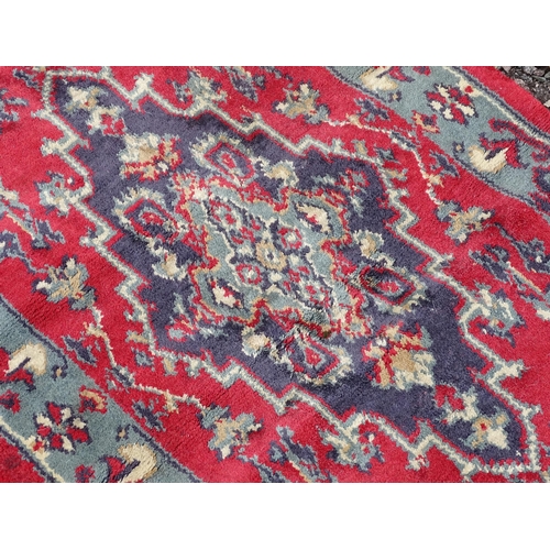702 - Carpet / Rug : A pair of red and blue ground rugs with floral and folate detail.  Each approx 53