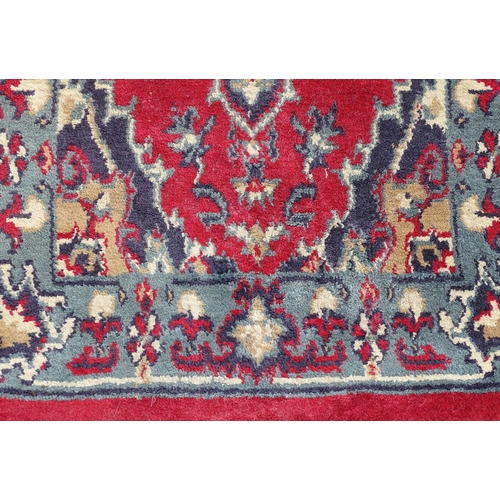 702 - Carpet / Rug : A pair of red and blue ground rugs with floral and folate detail.  Each approx 53
