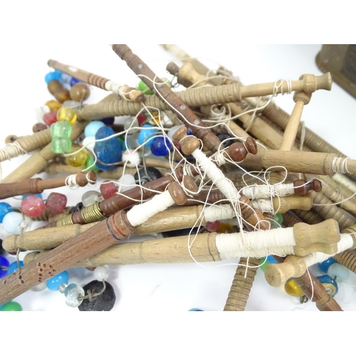 778 - A quantity of assorted 20thC turned wooden lace bobbins, many with decorative spangles. Contained wi... 