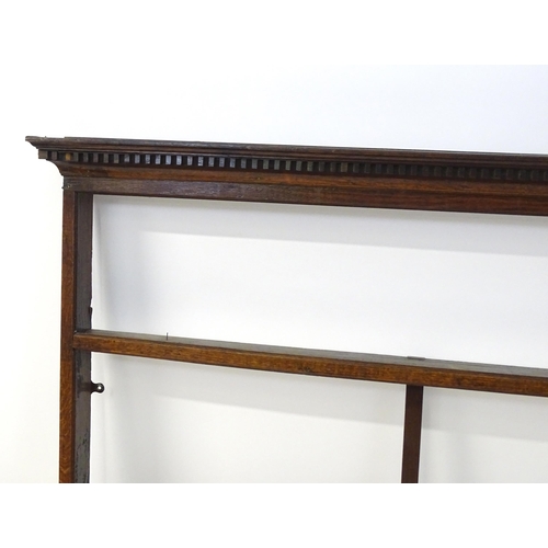 860 - An 18thC oak plate rack with a dentil moulded frieze. 75