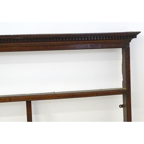 860 - An 18thC oak plate rack with a dentil moulded frieze. 75