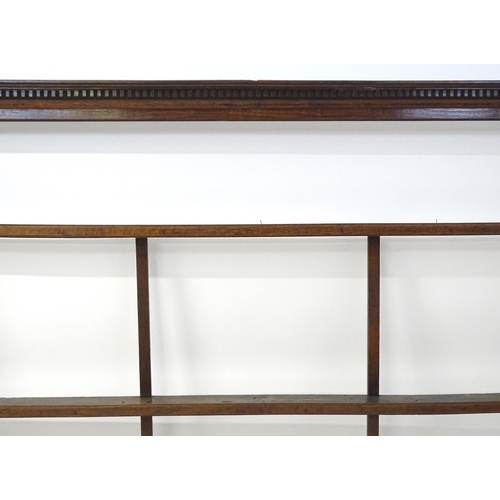 860 - An 18thC oak plate rack with a dentil moulded frieze. 75