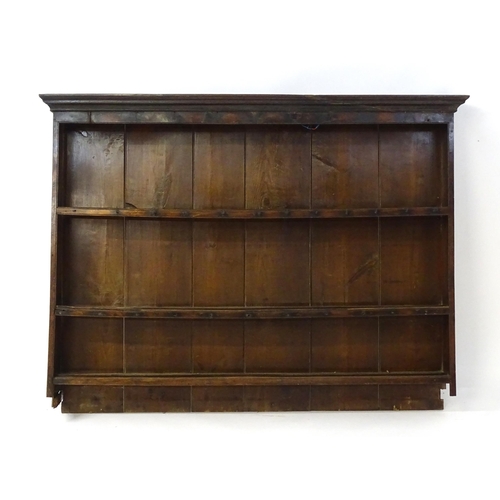 896 - An 18thC oak plate rack with a moulded cornice, shaped frieze and two cupboards. 74