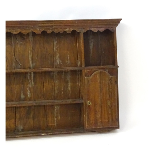 896 - An 18thC oak plate rack with a moulded cornice, shaped frieze and two cupboards. 74