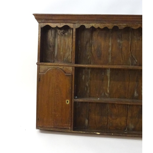 896 - An 18thC oak plate rack with a moulded cornice, shaped frieze and two cupboards. 74