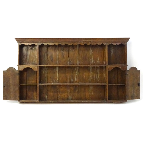 896 - An 18thC oak plate rack with a moulded cornice, shaped frieze and two cupboards. 74