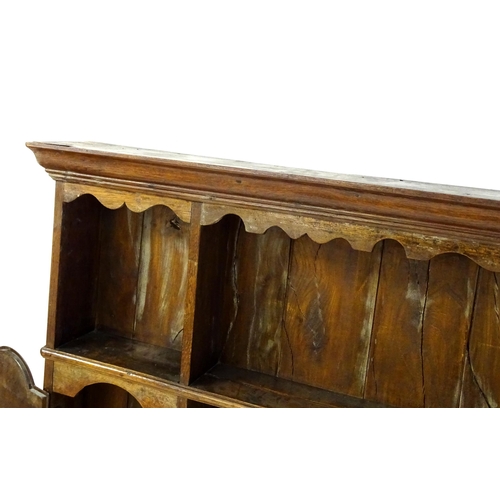 896 - An 18thC oak plate rack with a moulded cornice, shaped frieze and two cupboards. 74