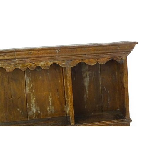 896 - An 18thC oak plate rack with a moulded cornice, shaped frieze and two cupboards. 74