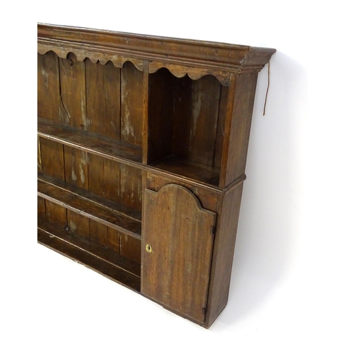 896 - An 18thC oak plate rack with a moulded cornice, shaped frieze and two cupboards. 74