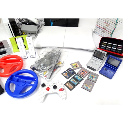 673 - Toys: Two Nintendo Wii games consoles and accessories to include Wii controllers, balance board, var... 