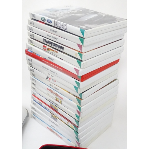 673 - Toys: Two Nintendo Wii games consoles and accessories to include Wii controllers, balance board, var... 