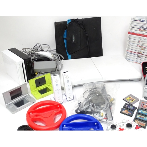 673 - Toys: Two Nintendo Wii games consoles and accessories to include Wii controllers, balance board, var... 