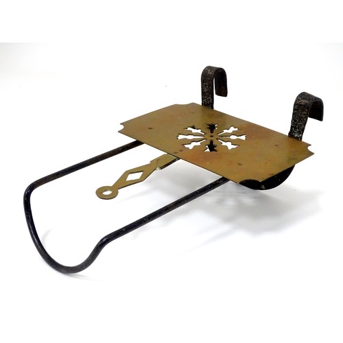 419 - A Victorian brass and cast iron sliding fireside trivet with hanging hooks and pierced detail. Appro... 