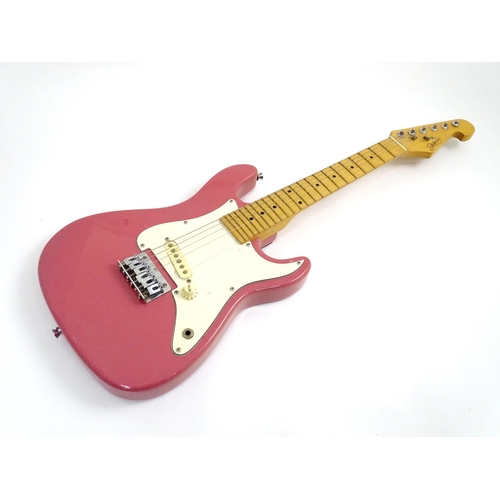 222 - A student's 3/4 size electric guitar by Jasmin, in pink finish with double cutaway contoured body, s... 