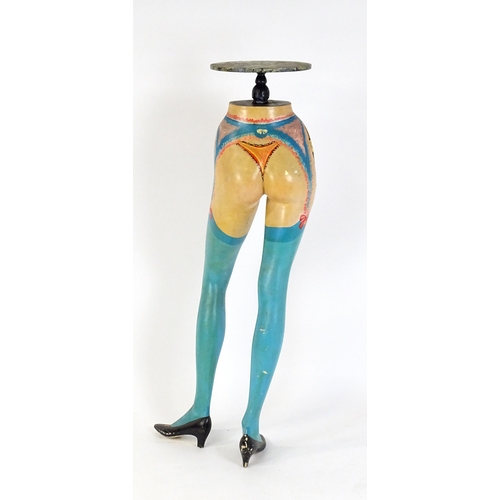 86 - A late 20thC stand raised on a model / mannequin of a woman's legs with painted lingerie detail. 49