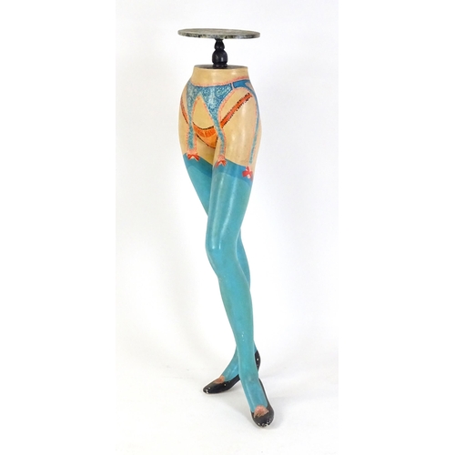 86 - A late 20thC stand raised on a model / mannequin of a woman's legs with painted lingerie detail. 49