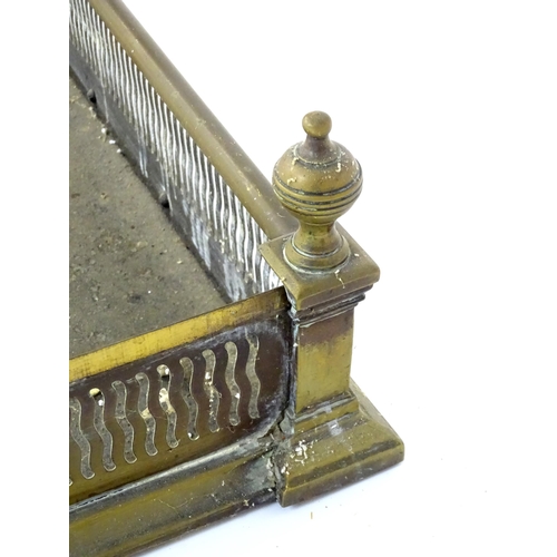 865 - A 19thC brass fire fender, with reticulated waved detail and finials at the corners, approx 40 1/2