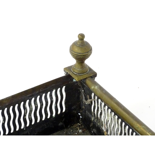 865 - A 19thC brass fire fender, with reticulated waved detail and finials at the corners, approx 40 1/2