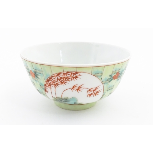 8 - A Chinese famille verte bowl decorated with stylised bamboo and flowers. Character marks under. Appr... 