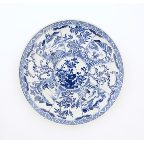 20 - A Chinese blue and white plate decorated with central taihu rock and flowers, bordered by figures in... 