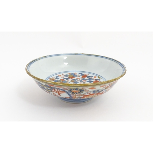 21 - A small Oriental dish decorated in the Imari palette, the centre with stylised fruit tree, the rever... 