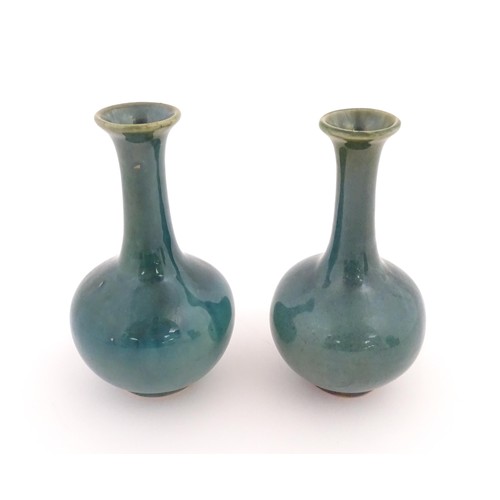 22 - A pair of Chinese bottle vases with flared rim in a blue glaze. Approx. 5 3/4