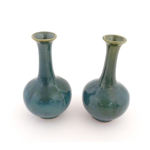 22 - A pair of Chinese bottle vases with flared rim in a blue glaze. Approx. 5 3/4