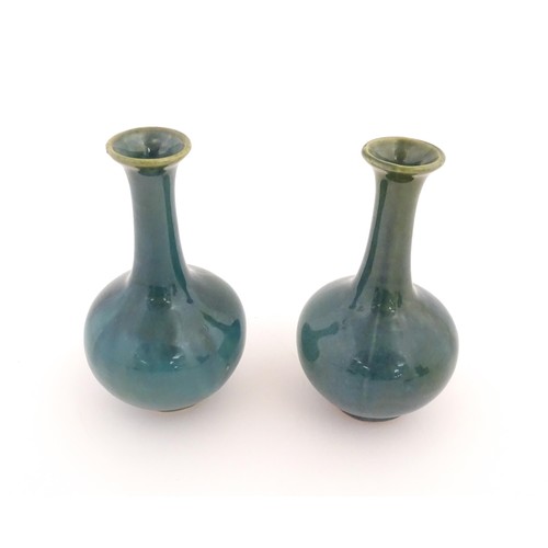 22 - A pair of Chinese bottle vases with flared rim in a blue glaze. Approx. 5 3/4