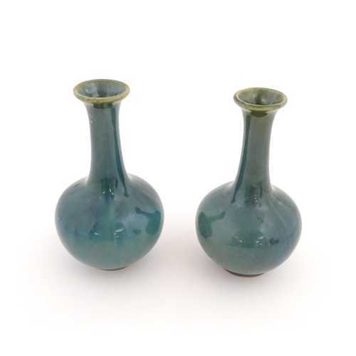 22 - A pair of Chinese bottle vases with flared rim in a blue glaze. Approx. 5 3/4