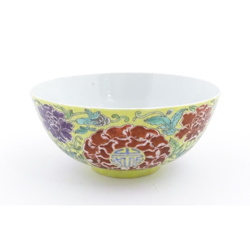 37 - A Chinese famille jeune bowl decorated with flowers, foliage and auspicious symbols. Character marks... 