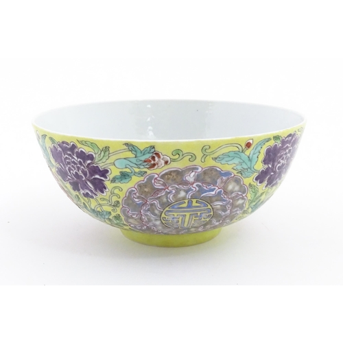 37 - A Chinese famille jeune bowl decorated with flowers, foliage and auspicious symbols. Character marks... 