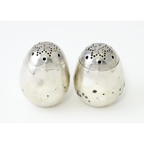 390 - A pair of Victorian silver pepperettes of egg form. Hallmarked London 1883 maker William Hutton & So... 