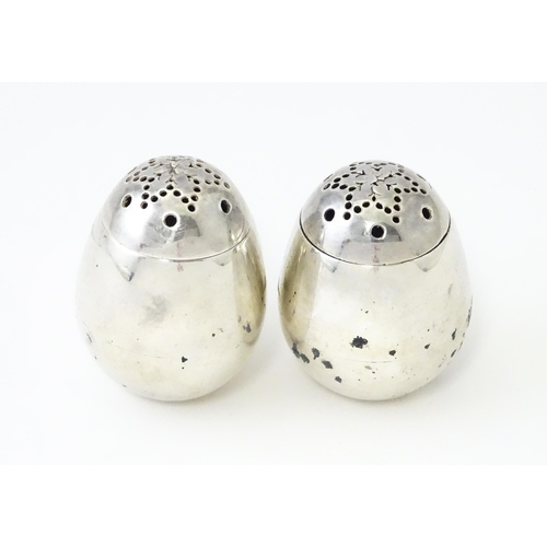 390 - A pair of Victorian silver pepperettes of egg form. Hallmarked London 1883 maker William Hutton & So... 