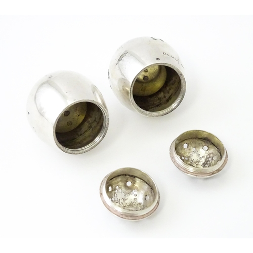 390 - A pair of Victorian silver pepperettes of egg form. Hallmarked London 1883 maker William Hutton & So... 