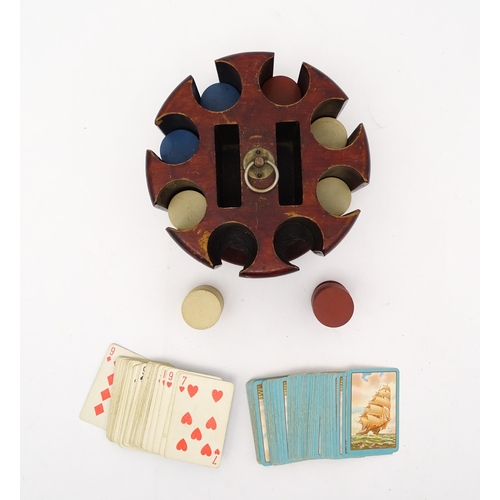 859 - Toys: A 20thC revolving gaming counter /  poker chip stand with two packs of playing cards with clip... 