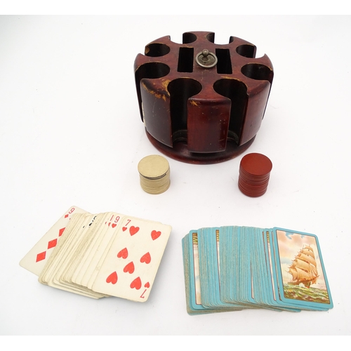 859 - Toys: A 20thC revolving gaming counter /  poker chip stand with two packs of playing cards with clip... 